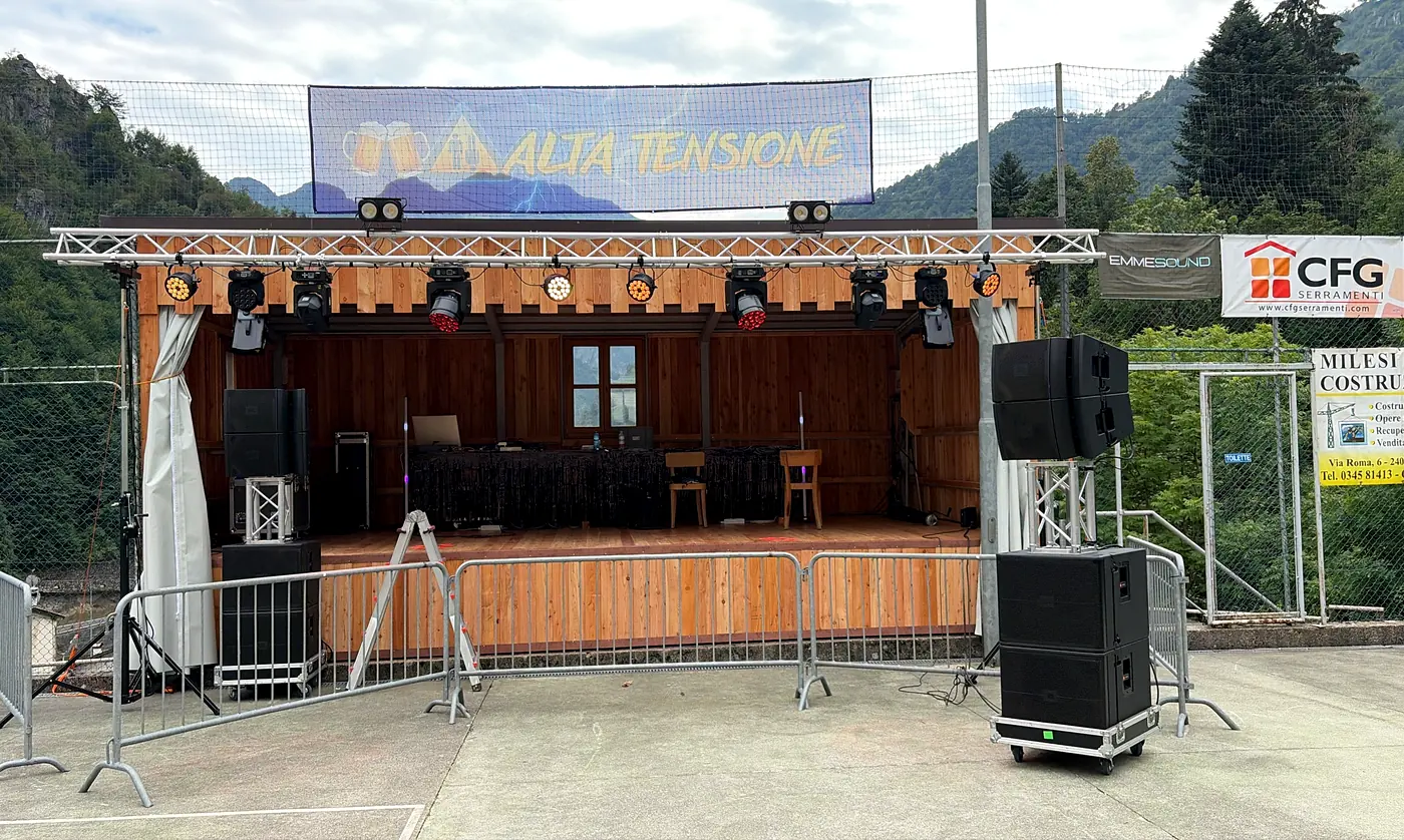 Palco con americana, fari e casse montato per una festa in montagna