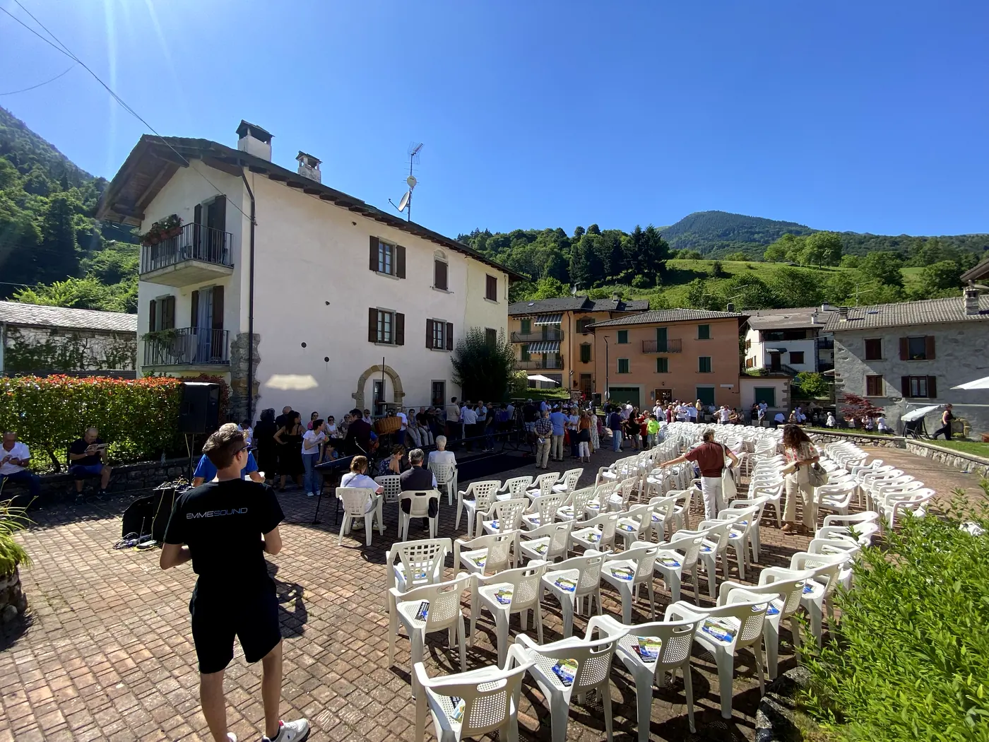 Piazza di paese allestita con sedie e impianto audio per uno spettacolo